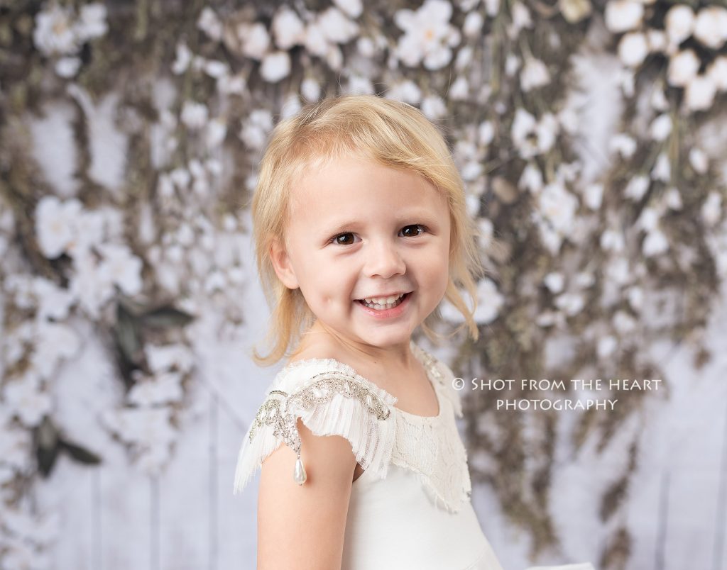 little girl in white dollcake dress with white floral flower background, atlanta Georgia child photographer