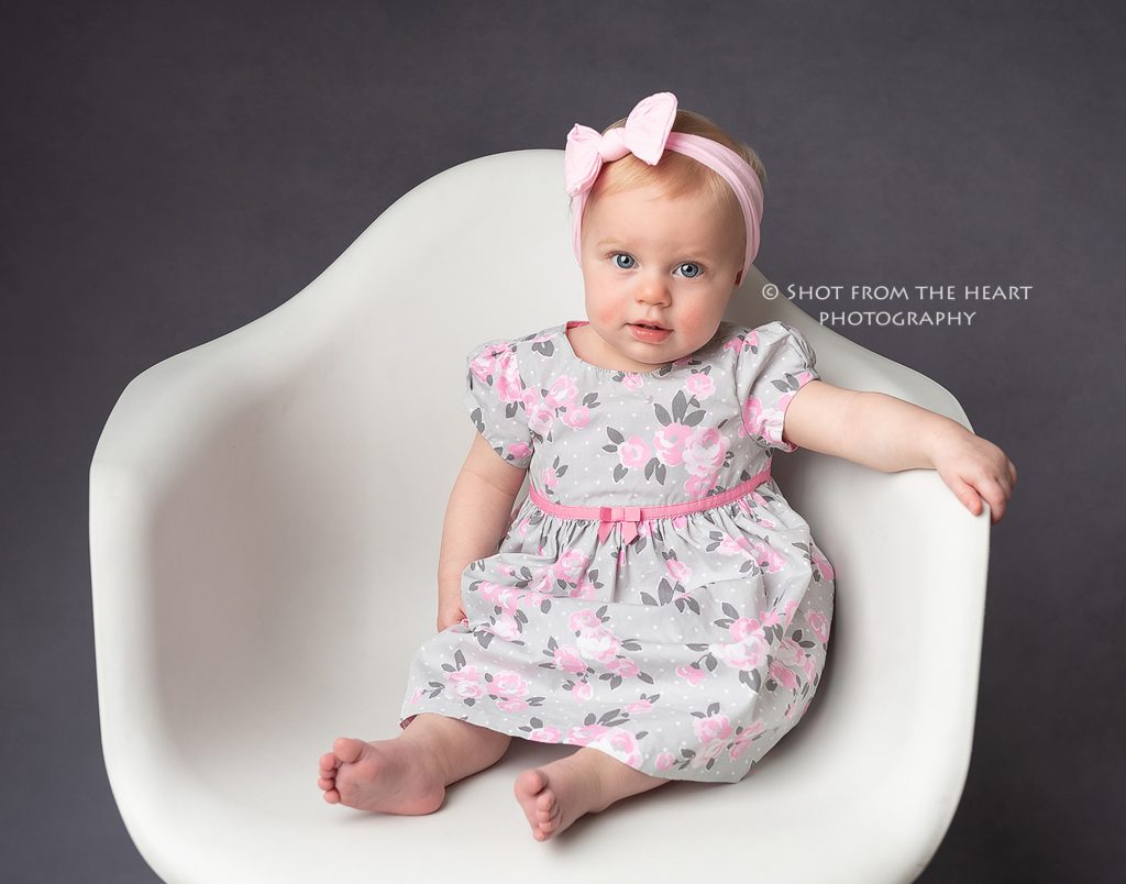 first birthday baby pictures, girl sit-in non white chair with grey background, canton ga baby photographer