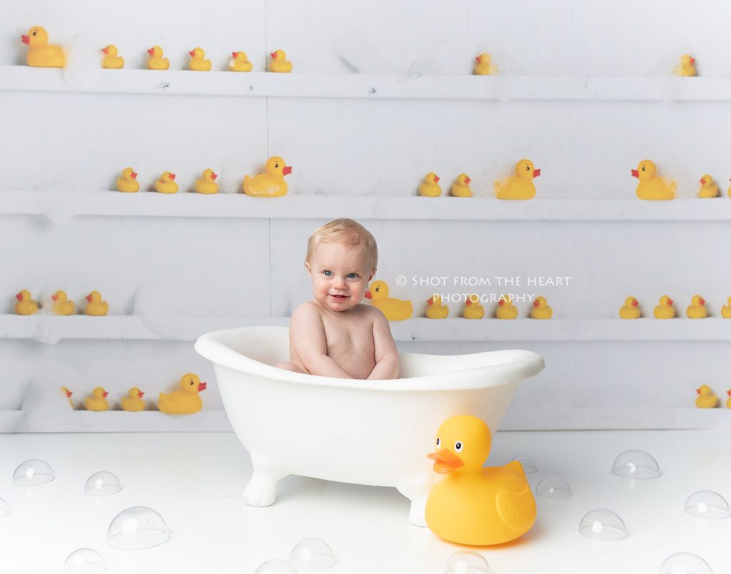 Bubble bath with rubber ducky as part of a photo session after a first birthday cake smash. 