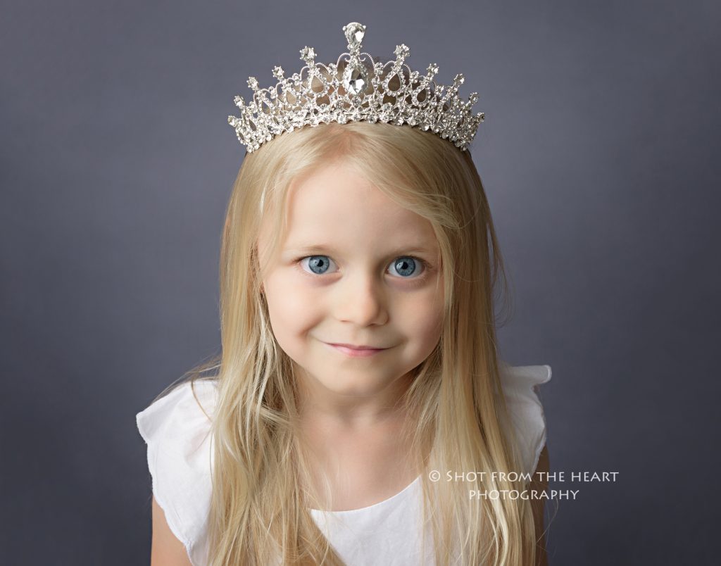 professional child photography girl in white dress wearing princess crown tiara