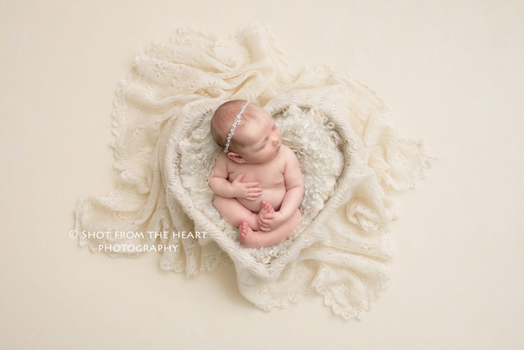 newborn baby girl in white heart shaped prop with vintage lace boho Alpharetta