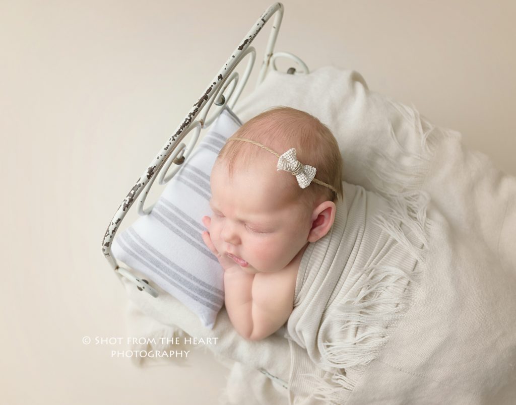 newborn baby girl in tiny bed, professional newborn photographer near Alpharetta Georgia 