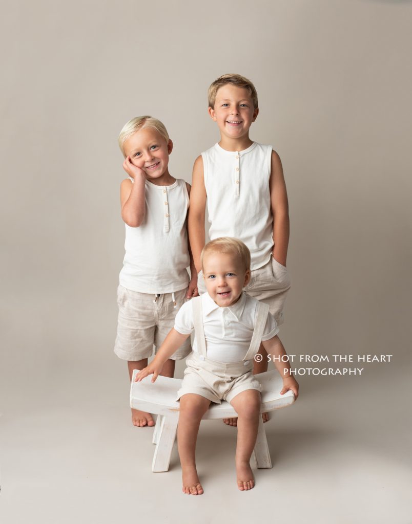 Three brothers in khaki and white on neutral backdrop