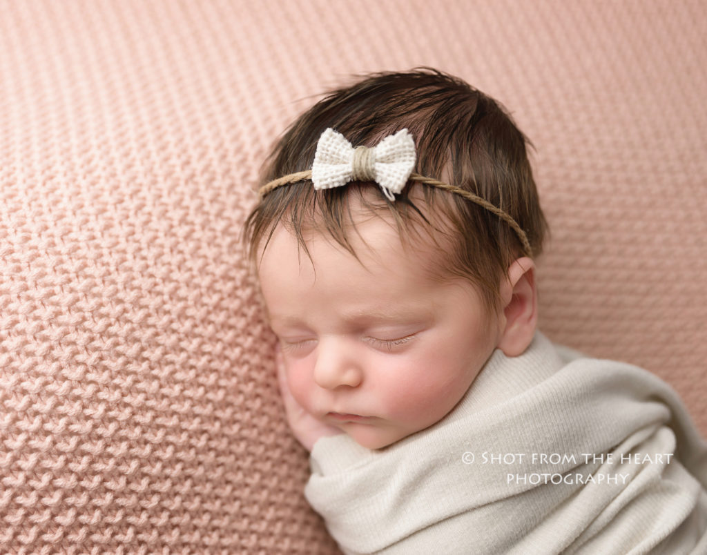newborn baby girl photography with bow simple swaddle pink